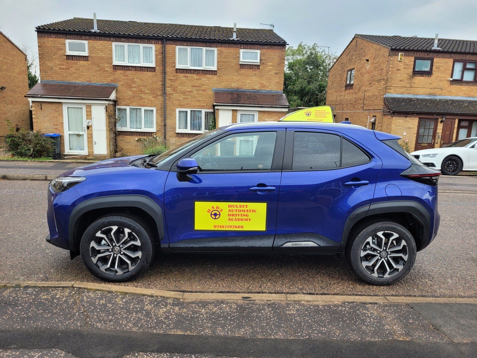 Friendly driving instructor sitting beside a calm learner during an automatic driving lesson in Northampton